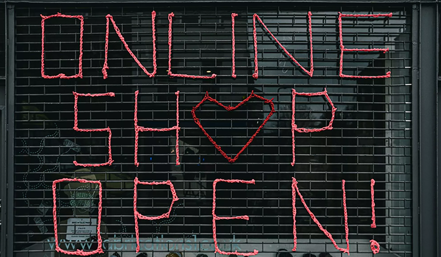 In einem Schaufenster steht mit Leuchtschrift "Online Shop Open"