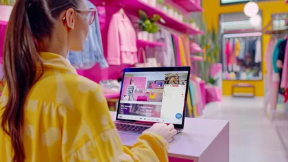 Eine Frau sitzt vor dem Laptop in einem Shop Room.