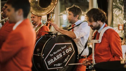 Musiker in orangen Anzügen.