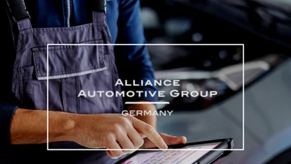 Ein Mann steht in einer Autowerkstatt und hält ein Tablet in der Hand – Symbol für die Einführung eines digitalen Produktkatalogs mit Pimcore-Integration bei der Alliance Automotive Group.