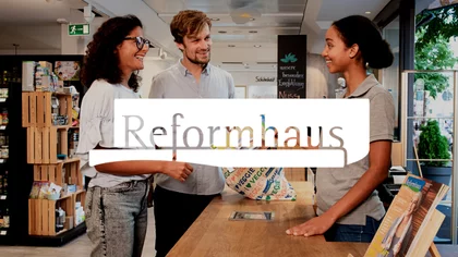 2 Menschen stehen in einer Reformhaus Filiale und reden mit der Angestellten. Darüber das Logo des NETFORMIC Kunden Reformhaus