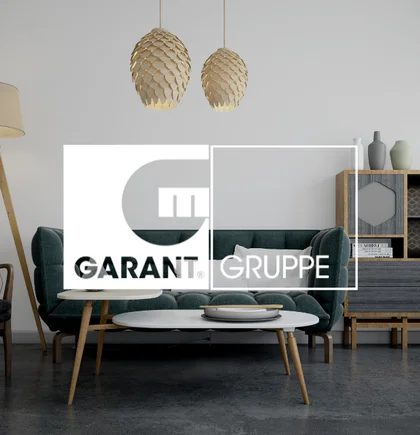 Ein stilvoll eingerichtetes Wohnzimmer. Darüber das Logo von NETFORMIC Kunden Garant Gruppe