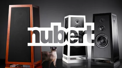 Three high-end Nubert speakers with a light-colored cat walking between them, and the Nubert logo above – representing the NETFORMIC customer case in the D2C segment for premium audio commerce
