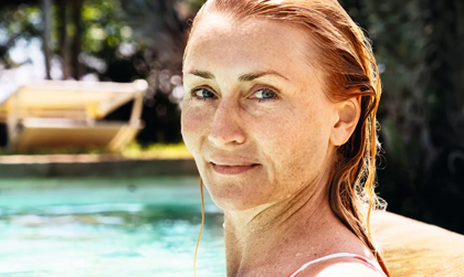 Eine Frau im Pool schaut in die Kamera.