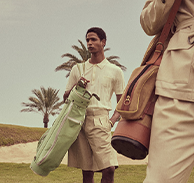 Zwei Männer in beige Golf-Kleidung und Golfausrüstung.