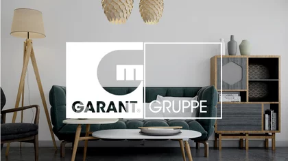 Ein stilvoll eingerichtetes Wohnzimmer. Darüber das Logo von NETFORMIC Kunden Garant Gruppe