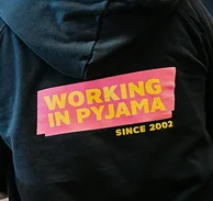 Ein Oberteil mit der Aufschrift ‚Working in Pyjamas‘ – Symbol für die Remote-First-Kultur bei NETFORMIC, die Flexibilität, Wohlbefinden und digitale Freiheit betont