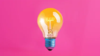 Gelbe Glühbirne auf rosa Hintergrund.