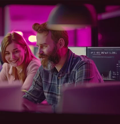 Eine Frau und ein Mann sitzen gemeinsam vor einem PC – Symbol für die effiziente Nutzung von Produktdaten und die Entwicklung individualisierter Lösungen innerhalb von Verbundgruppen.