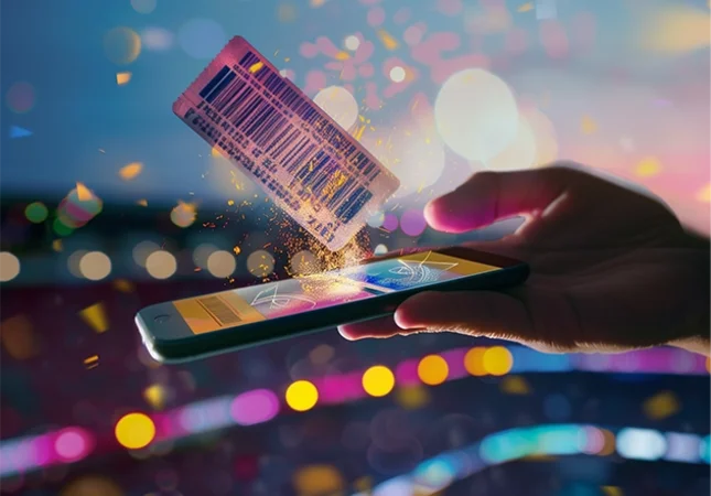 Eine Hand hält ein Smartphone, auf dem ein ausgedrucktes Ticket liegt – Symbol für die digitale Transformation im Profisport: von Ticketing über Merchandise bis zu Content-Plattformen und Web TV.