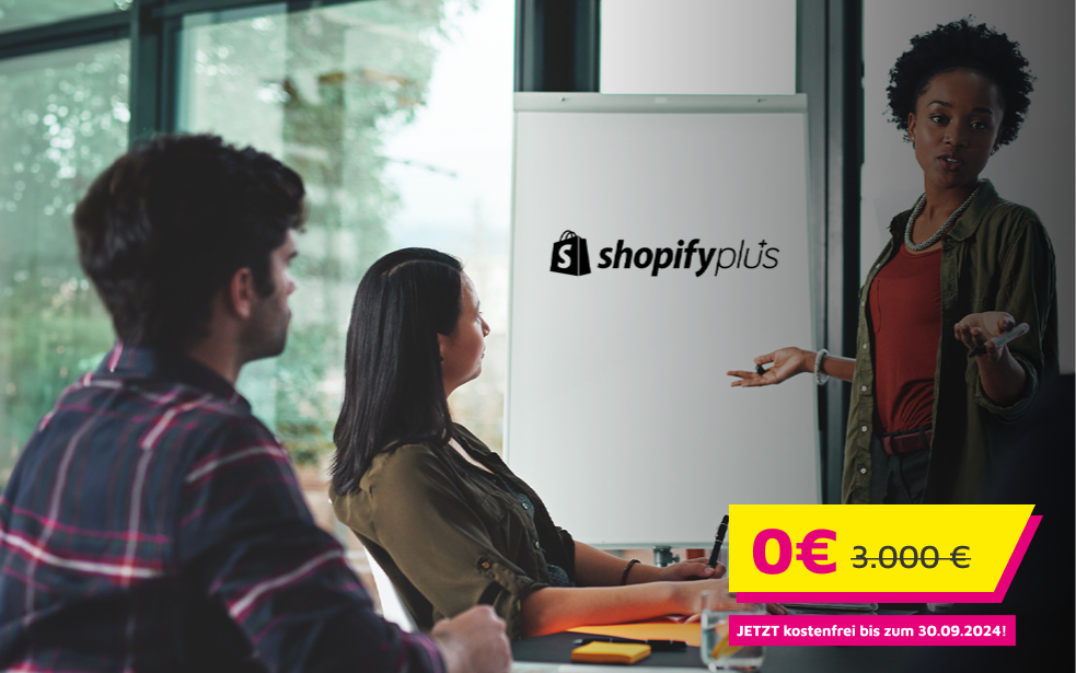 Ein Mann und eine Frau hören einem Vortrag über ShopifyPlus zu. 