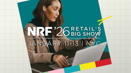 Female digital professional using a laptop and smartphone at a retail technology event, representing omnichannel commerce and digital transformation.