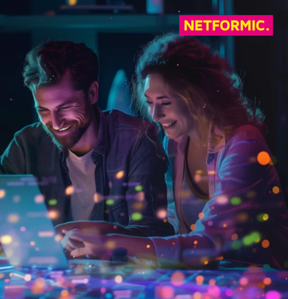 Two marketing professionals collaborating on a laptop with digital data streams, representing NETFORMIC’s expertise in data-driven customer engagement and marketing automation
