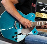 Session Kundencase Nahaufnahme von einem Mann, der blaue Gitarre spielt