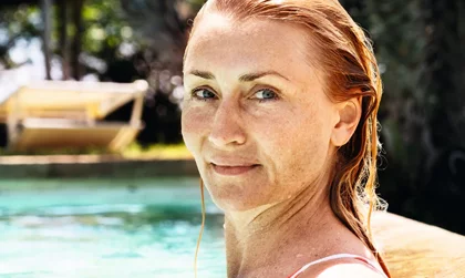 Reformhaus Kundencase Eine Frau im Pool schaut in die Kamera.
