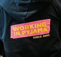 Remote First: Bei NETFORMIC ist ‚Working in Pyjamas‘ kein Witz, sondern gelebte Kultur Ein Oberteil mit der Aufschrift ‚Working in Pyjamas‘ – Symbol für die Remote-First-Kultur bei NETFORMIC, die Flexibilität, Wohlbefinden und digitale Freiheit betont