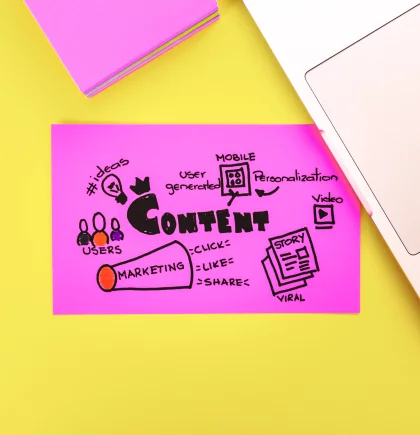 Shopware Evolve Content Ein Haftnotizstapel in magenta, ein Haftnotiz in magenta mit aufgeschriebenen Contentplan, ein Teil von Laptoptastatur oben rechts. Gelber Hintergrund.